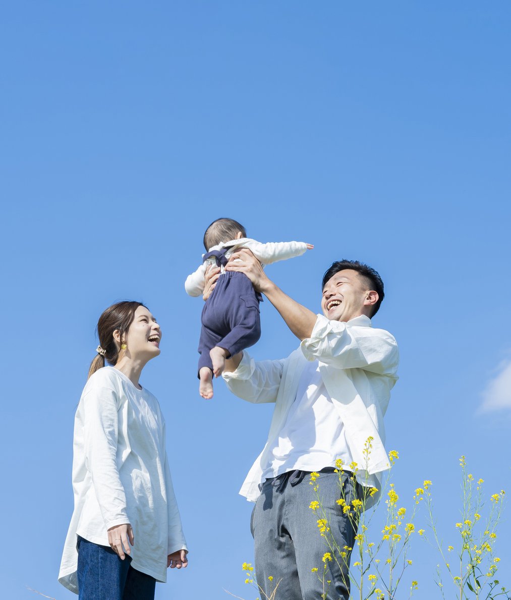 parents-holding-their-baby-high-blue-sky-1